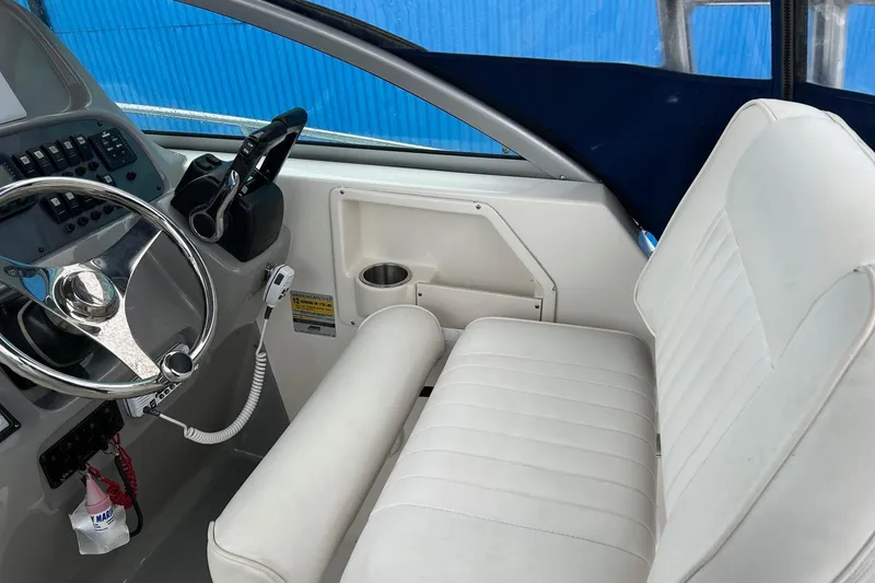 Slide: The Image of 2011 Robalo R265 Walkaround helm with steering wheel and white captain's seat. - 6
