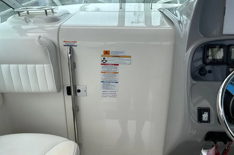 Slide: The Image of 2011 Robalo R265 Walkaround boat cockpit with steering wheel and control panel. - 7