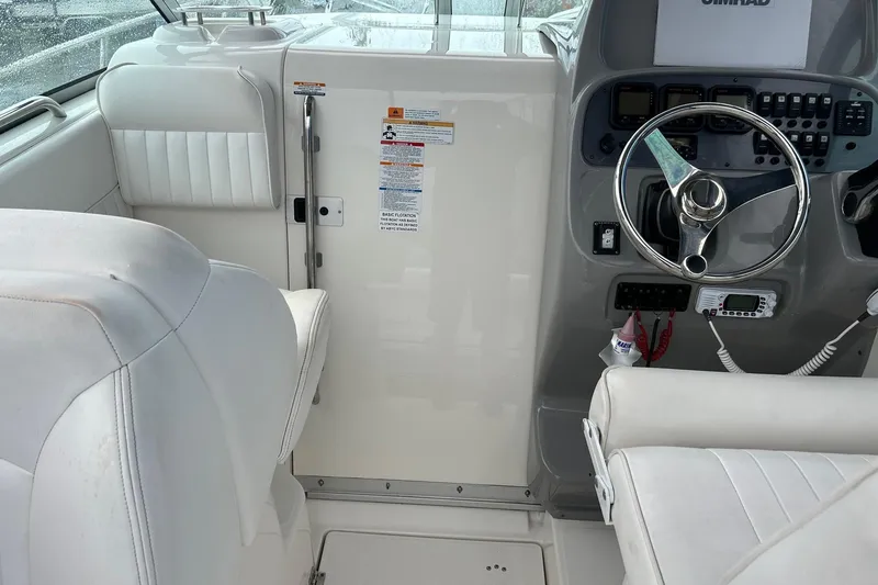 Slide: The Image of 2011 Robalo R265 Walkaround boat cockpit with steering wheel and white seating. - 8
