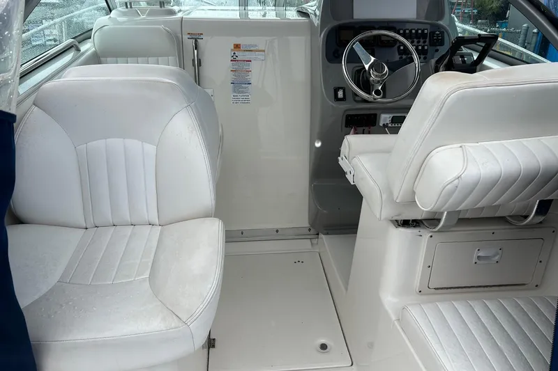 Slide: The Image of Interior of 2011 Robalo R265 Walkaround boat with white seating and steering console. - 9