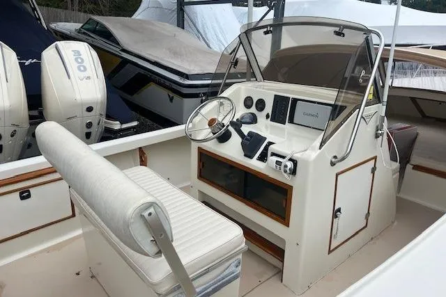 Slide: The Image of 1993 Padebco V-21 boat interior with steering wheel, dashboard, and seating. - 14
