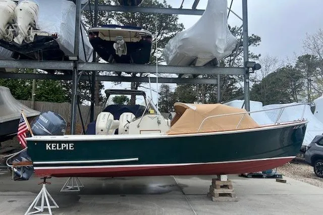 Slide: The Image of 1993 Padebco V-21 boat with green hull and tan canopy, stored on stands. - 6