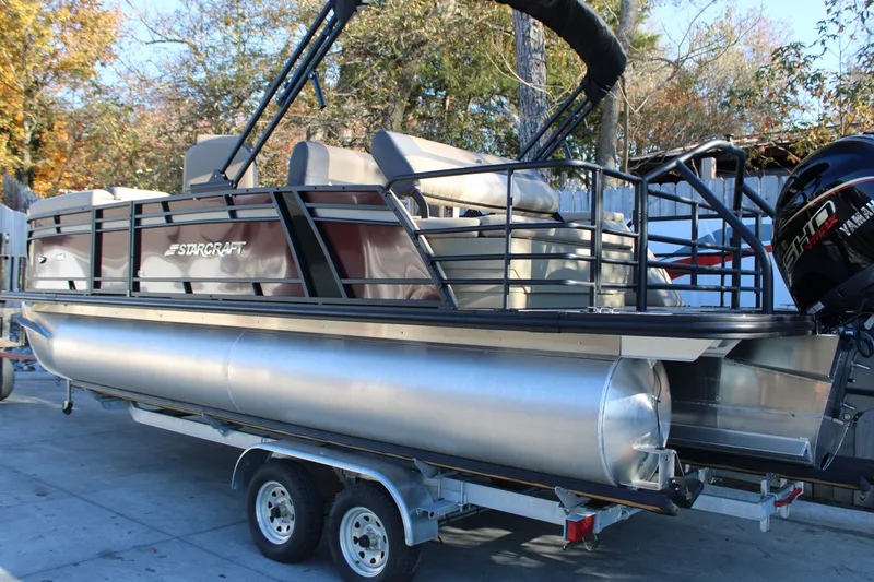 Slide: The Image of Starcraft EXS 3 DL 2026 pontoon boat with Yamaha engine outdoors. - 2