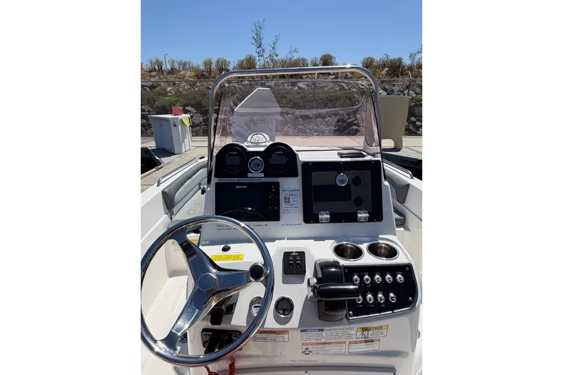 Slide: The Image of 2023 NauticStar 211 Hybrid boat dashboard with steering wheel and control panel. - 10