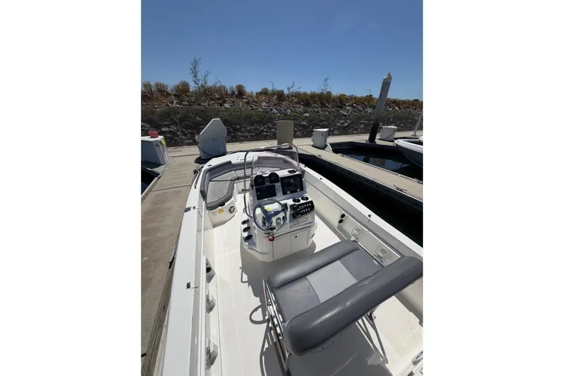 Slide: The Image of 2023 NauticStar 211 Hybrid boat docked, featuring a sleek console and seating. - 3