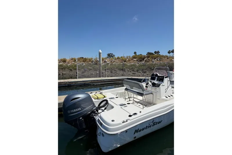 Slide: The Image of 2023 NauticStar 211 Hybrid boat docked with Yamaha outboard motor. - 4