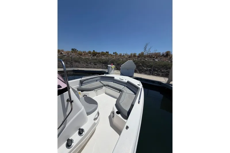 Slide: The Image of 2023 NauticStar 211 Hybrid boat docked, featuring spacious seating and sleek design. - 5