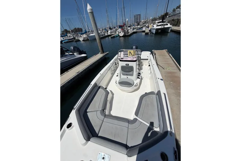 Slide: The Image of 2023 NauticStar 211 Hybrid boat docked at a marina with clear blue skies. - 6