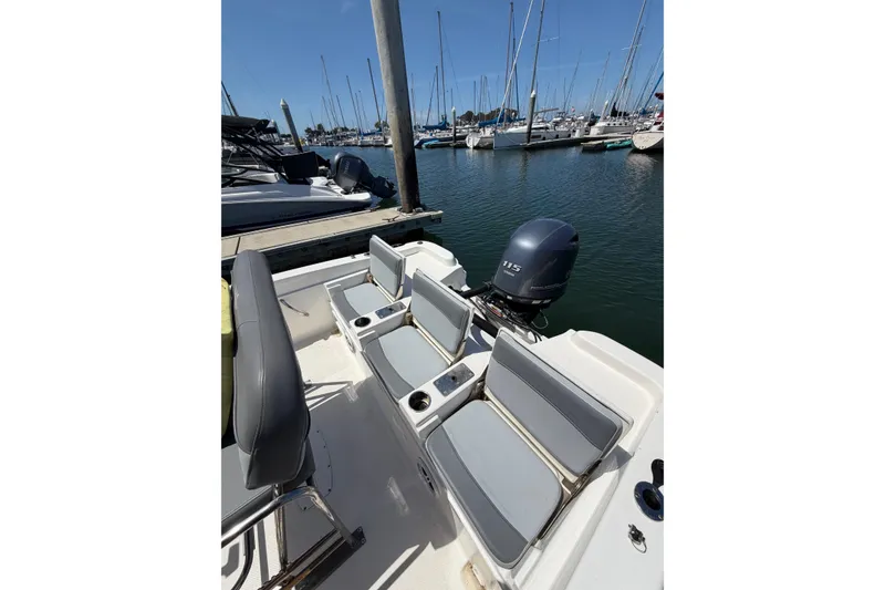 Slide: The Image of 2023 NauticStar 211 Hybrid boat with seating and outboard motor at marina. - 8