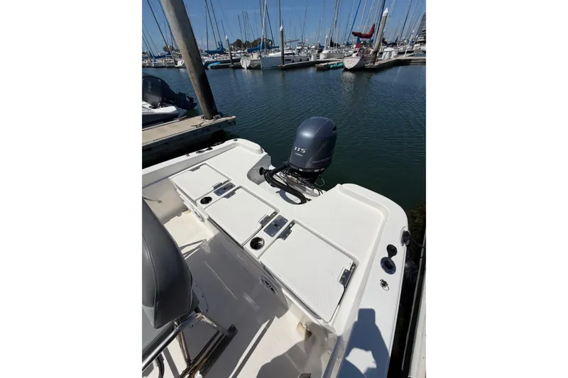 Slide: The Image of 2023 NauticStar 211 Hybrid boat docked, featuring a 115 horsepower outboard motor. - 9