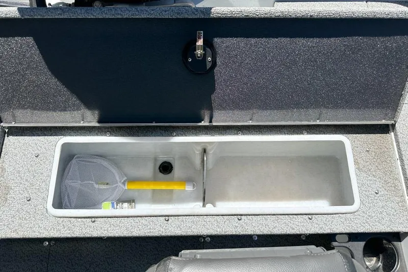 Slide: The Image of Open storage compartment in 2026 Lund 1700 Explorer Sport boat with fishing net and accessories. - 24