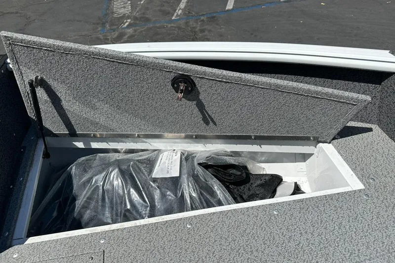 Slide: The Image of Open storage compartment in 2026 Lund 1700 Explorer Sport boat, revealing covered items. - 18