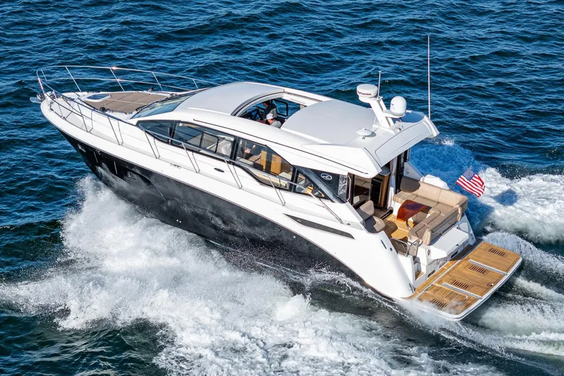 The Image of 2017 Sea Ray 460 Sundancer yacht cruising on open water, showcasing sleek design and luxury. - 0
