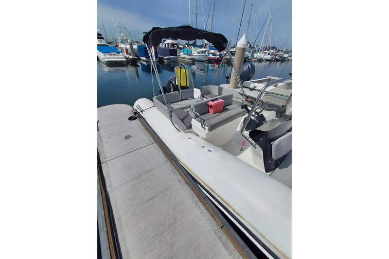 Slide: The Image of 2021 Zodiac N-ZO 680 boat docked at marina, featuring seating and canopy. - 3