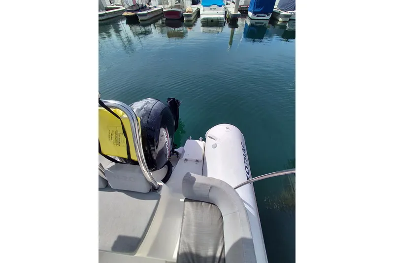 Slide: The Image of 2021 Zodiac N-ZO 680 boat docked in a marina, featuring an outboard motor. - 7