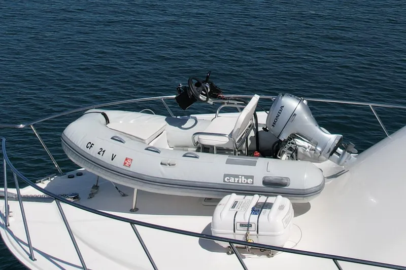 Slide: The Image of 2006 Cabo 40 Flybridge yacht with inflatable dinghy and Honda outboard motor on deck. - 10
