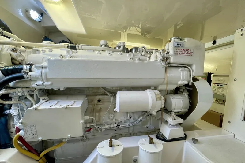 Slide: The Image of Engine room of a 2006 Cabo 40 Flybridge boat, showcasing a clean, white engine. - 104
