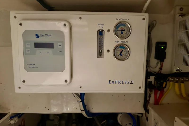 Slide: The Image of Blue Water desalination system on 2006 Cabo 40 Flybridge yacht, featuring pressure gauges and controls. - 114