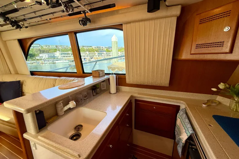 Slide: The Image of Interior of 2006 Cabo 40 Flybridge yacht with kitchen and marina view. - 23