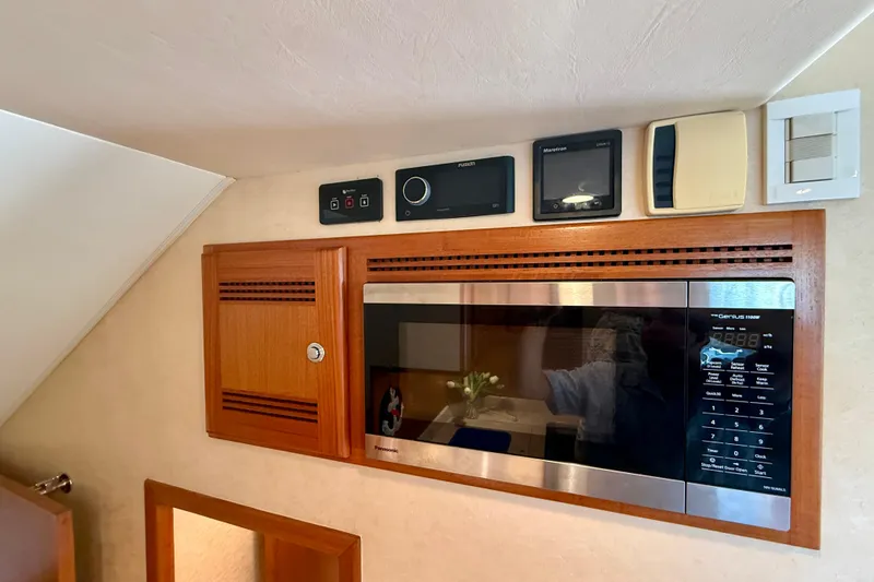 Slide: The Image of 2006 Cabo 40 Flybridge interior with microwave and control panels. - 24