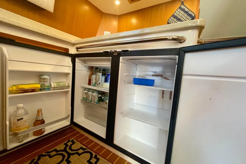 Slide: The Image of Open refrigerator in 2006 Cabo 40 Flybridge yacht kitchen, stocked with beverages and condiments. - 26