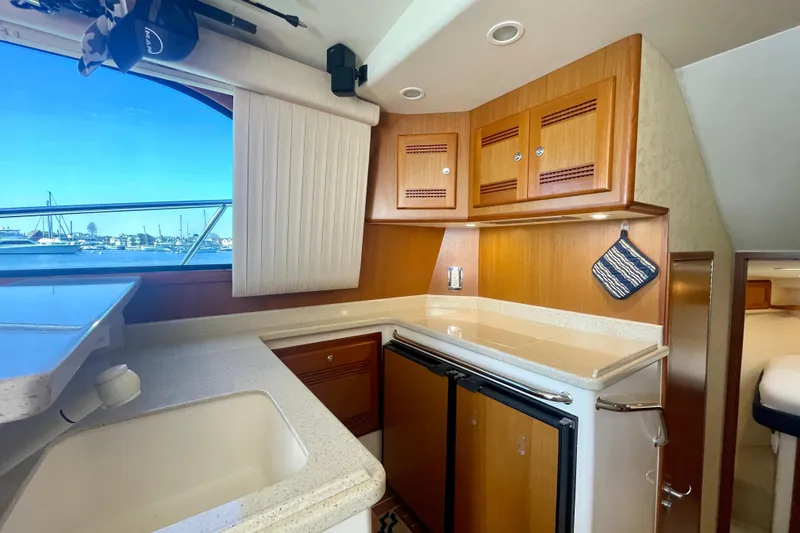 Slide: The Image of Luxurious 2006 Cabo 40 Flybridge yacht interior with modern kitchen and scenic window view. - 28