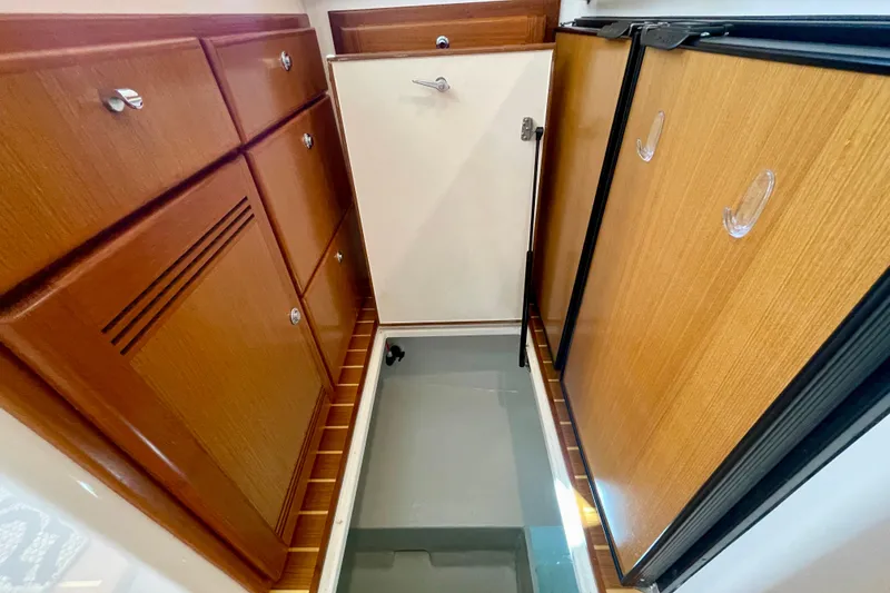Slide: The Image of Interior view of 2006 Cabo 40 Flybridge, featuring wooden cabinetry and storage compartments. - 32