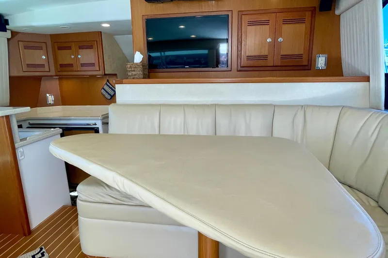 Slide: The Image of Luxurious interior of a 2006 Cabo 40 Flybridge yacht with leather seating and wooden cabinetry. - 36