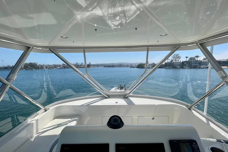 Slide: The Image of View from 2006 Cabo 40 Flybridge yacht's helm, overlooking serene waterfront and distant skyline. - 53