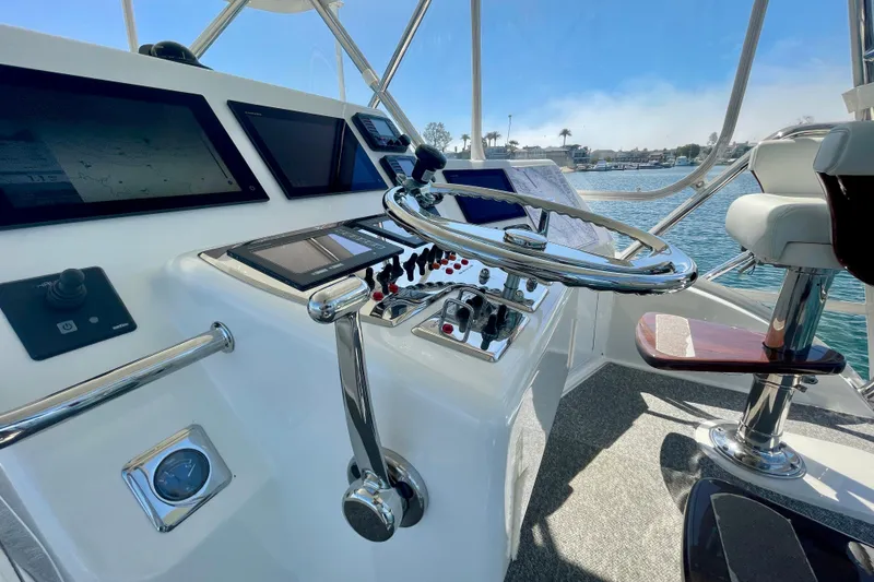 Slide: The Image of Helm of 2006 Cabo 40 Flybridge yacht with modern navigation equipment and controls. - 58