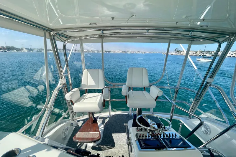 Slide: The Image of Flybridge of 2006 Cabo 40 yacht with dual captain chairs overlooking serene waters. - 60