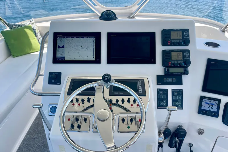 Slide: The Image of Helm of 2006 Cabo 40 Flybridge yacht with navigation screens and controls. - 66