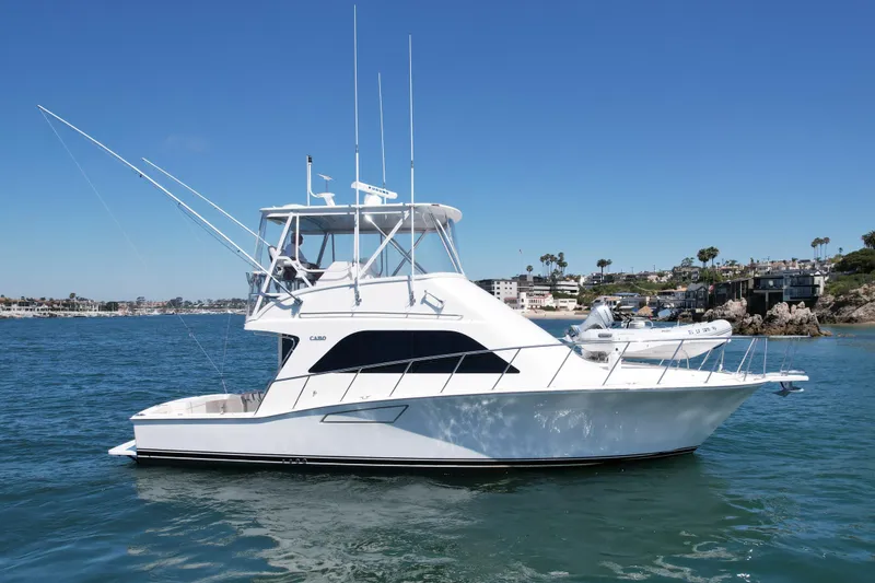 Slide: The Image of 2006 Cabo 40 Flybridge yacht cruising on a sunny day near coastal homes. - 7