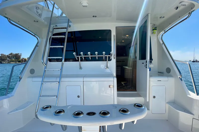 Slide: The Image of 2006 Cabo 40 Flybridge yacht stern view with ladder and open cabin door. - 76