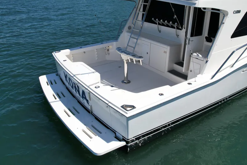 Slide: The Image of 2006 Cabo 40 Flybridge boat with spacious deck, ladder, and fishing rod holders on water. - 8