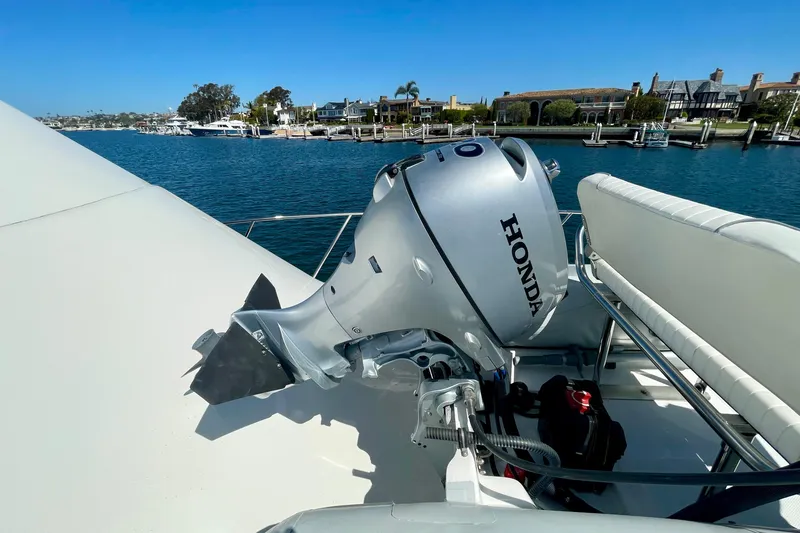 Slide: The Image of 2006 Cabo 40 Flybridge with Honda outboard motor, docked in a scenic marina. - 85