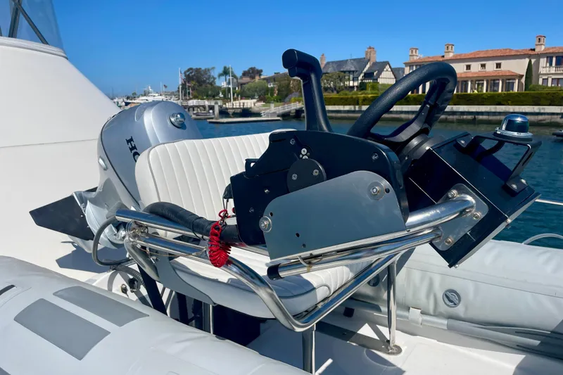 Slide: The Image of Helm of 2006 Cabo 40 Flybridge yacht with steering wheel and controls, docked by waterfront homes. - 89