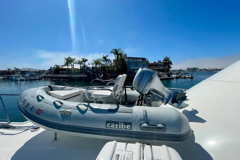 Slide: The Image of Inflatable boat with Honda motor on Cabo 40 Flybridge yacht, 2006 model, docked in sunny marina. - 92