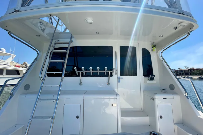 Slide: The Image of 2006 Cabo 40 Flybridge yacht with ladder and fishing rod holders, docked in marina. - 94