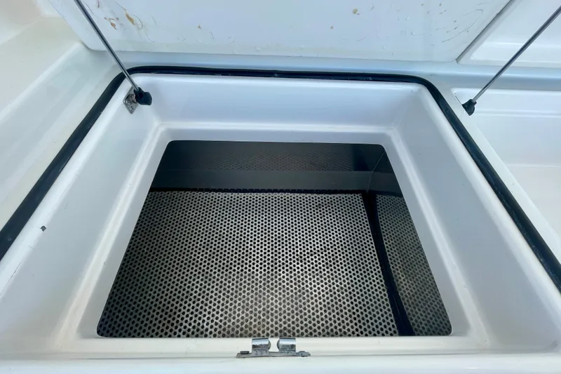 Slide: The Image of Open storage compartment on a 2006 Cabo 40 Flybridge boat, featuring a perforated mat. - 96