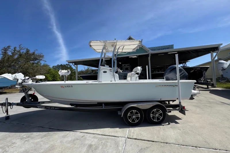 The Image of 2015 Sportsman Masters 227 Bay Boat on trailer, parked outdoors under clear sky. - 1