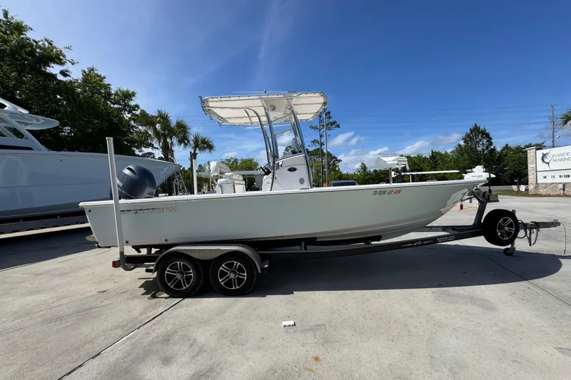 Slide: The Image of 2015 Sportsman Masters 227 Bay Boat on trailer, parked outdoors under clear blue sky. - 10