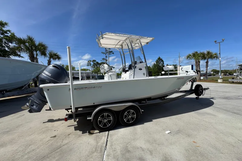 Slide: The Image of 2015 Sportsman Masters 227 Bay Boat on trailer, parked outdoors under clear blue sky. - 11