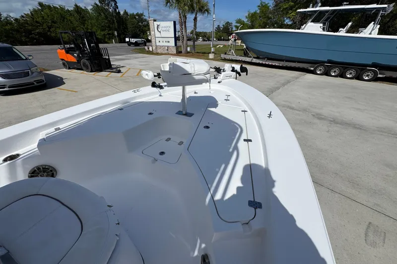 Slide: The Image of 2015 Sportsman Masters 227 Bay Boat on display at a marina with nearby vehicles. - 18