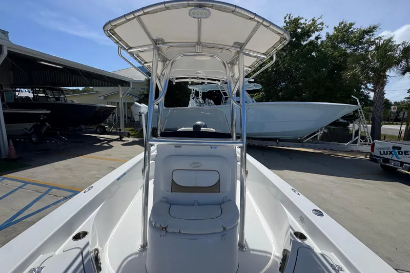 Slide: The Image of 2015 Sportsman Masters 227 Bay Boat with T-top, parked outdoors near other boats. - 25