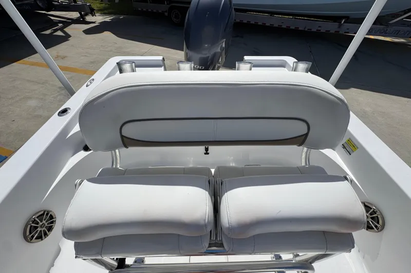 Slide: The Image of 2015 Sportsman Masters 227 Bay Boat interior seating with white cushions and cup holders. - 29