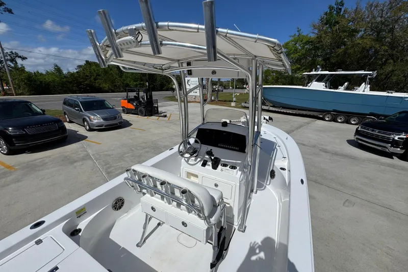 Slide: The Image of 2015 Sportsman Masters 227 Bay Boat with T-top, parked in a lot with vehicles. - 37