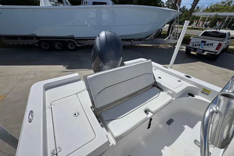 Slide: The Image of 2015 Sportsman Masters 227 Bay Boat with seating and motor, parked near a trailer and truck. - 40