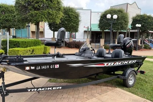 The Image of 2025 Tracker Pro 170 boat on trailer, parked outdoors near buildings and greenery. - 0