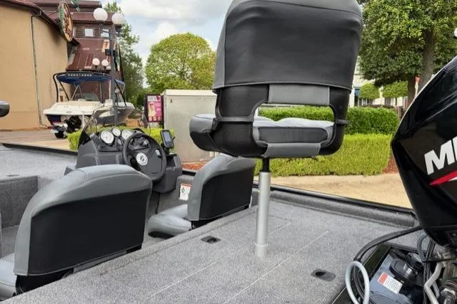 Slide: The Image of 2025 Tracker Pro 170 boat interior with seating and control panel, parked outdoors. - 11